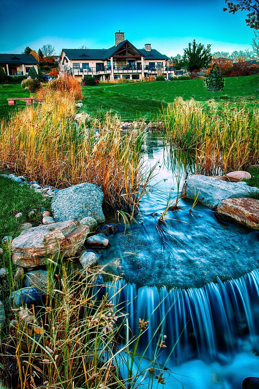 Natural stream with native grasses and mountain backdrop at Lake Valley Golf Club in autumn